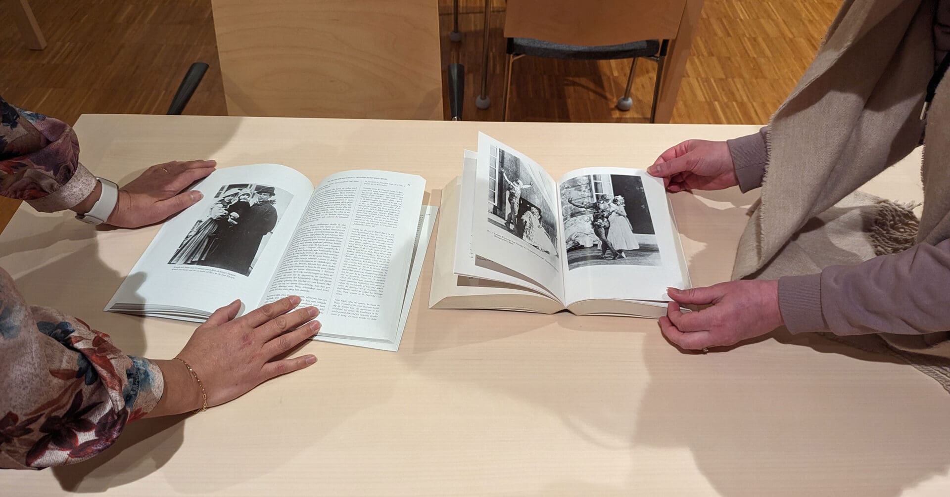 две женщины листают книгу на столе