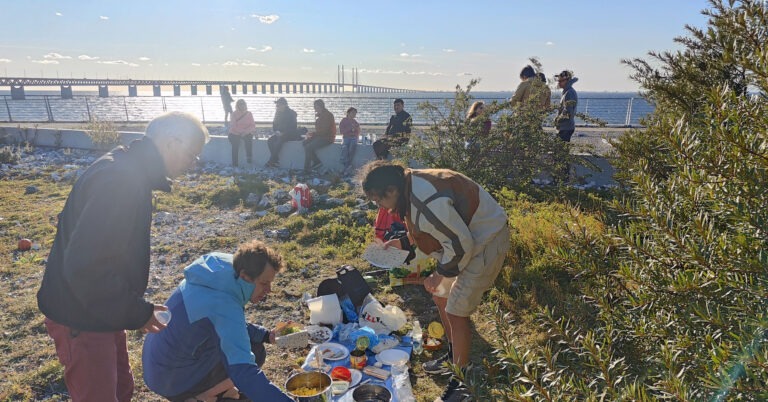 människor vid havet, bro i horisonten