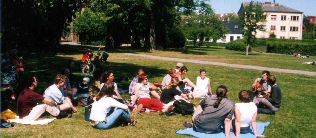 människor sittande på gräset i en park