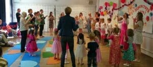 дети и взрослые танцуют хоровод в зале