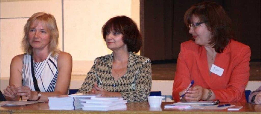 tre kvinnor som sitter bakom ett bord