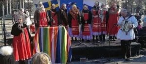sånggrupp i ryska folkdräkter som står på en scen utomhus