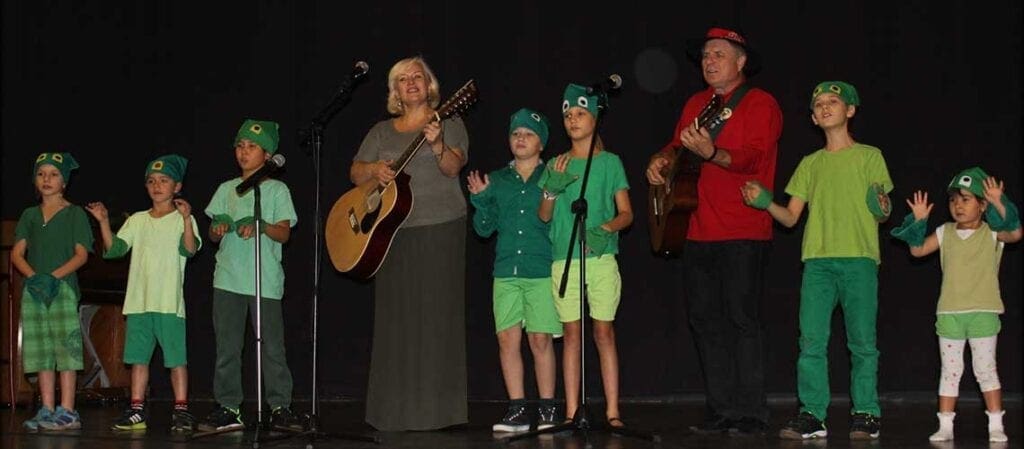 vuxna och barn som sjunger på scenen