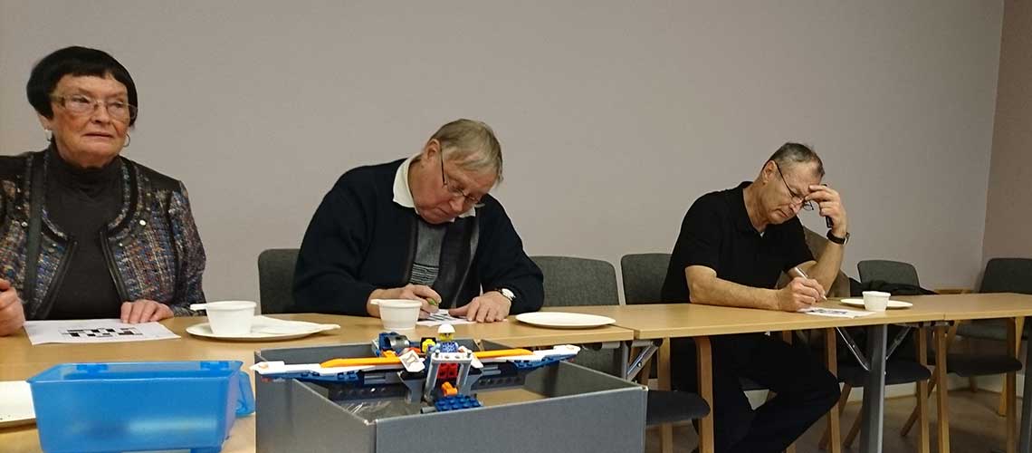 три человека, сидящие за столом, пишуя