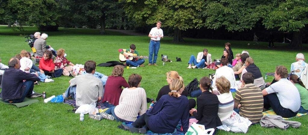 människor som sitter på gräset i en park