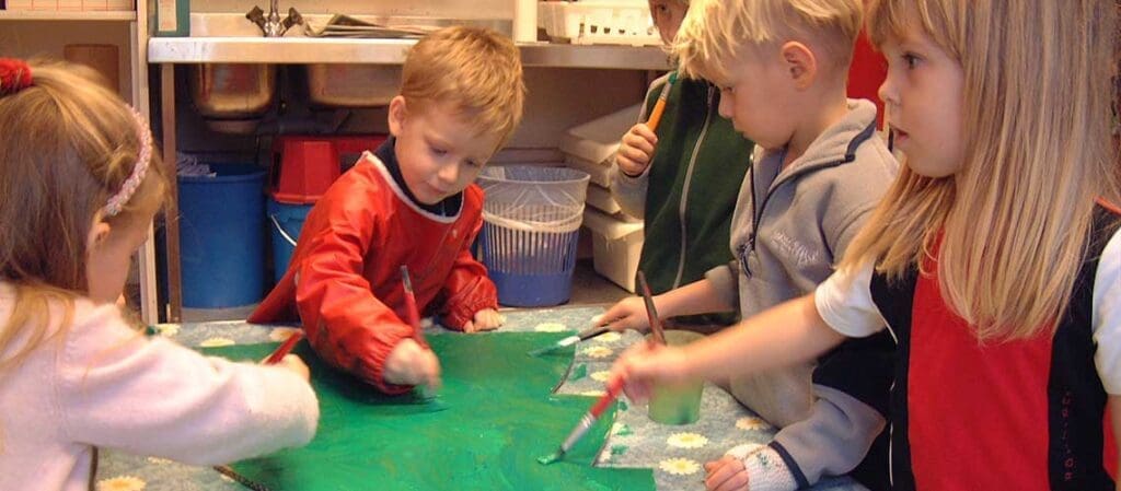barn som målar på ett grönt papper