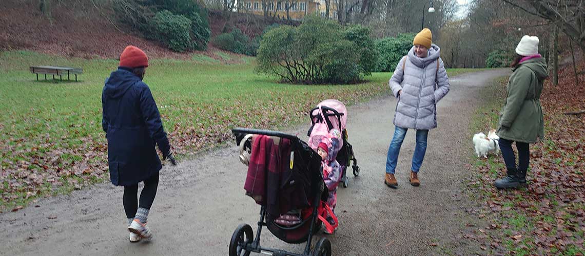 tre vuxna och ett barn i en park