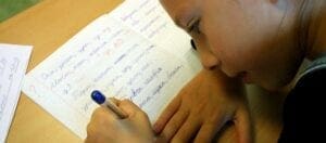 девочка, пишущая в тетради на русском языке