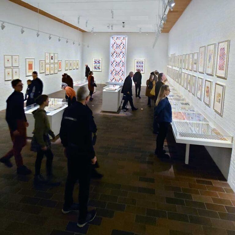 tavlor och besökare på en utställning