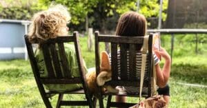 två barn som sitter på stolar utomhus