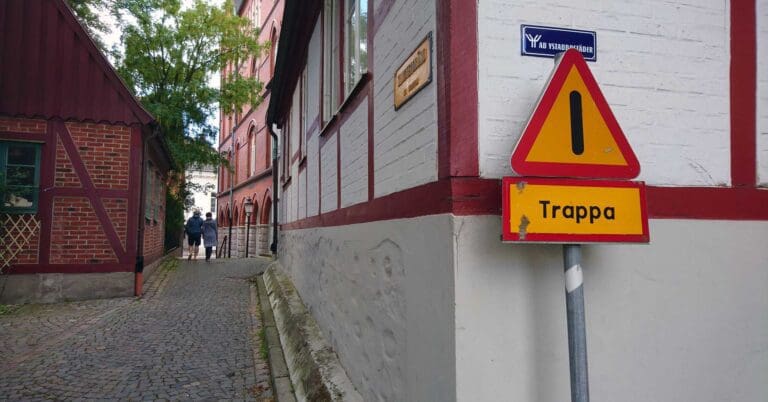 переулок с дорожным знаком, предупреждающем о лестнице