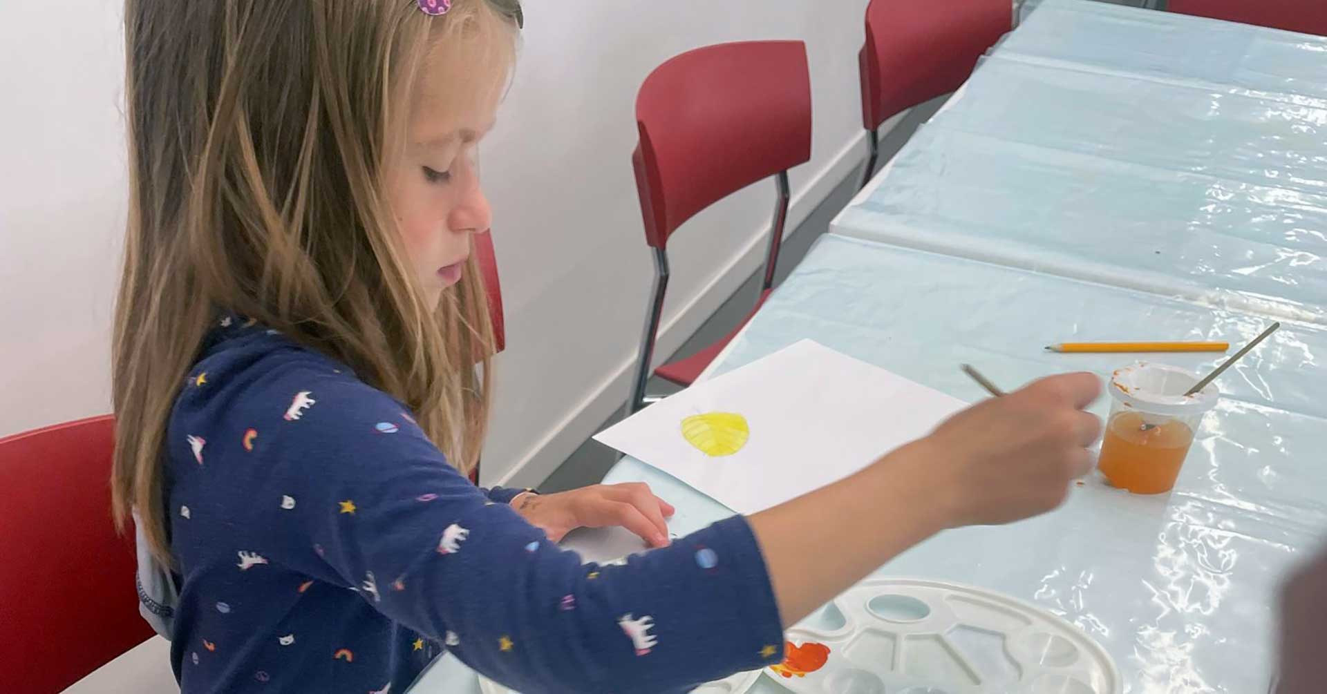 девочка рисует за столом