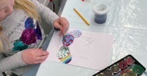 ett barn som målar ägg på ett papper