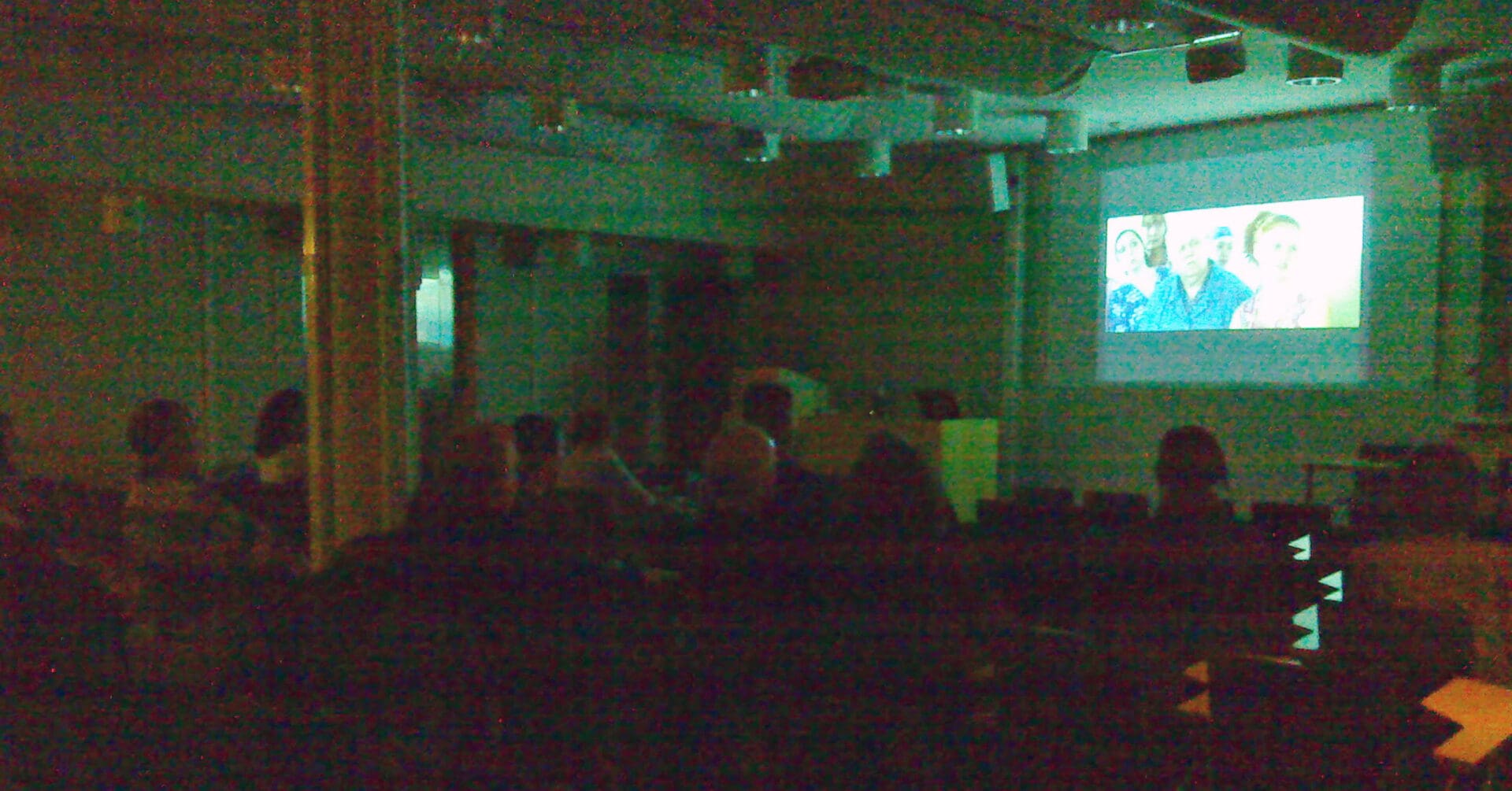 люди, смотрящие кино в актовом зале
