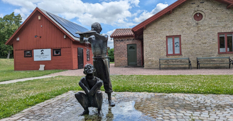 скульптура двох дітей перед двома будинками