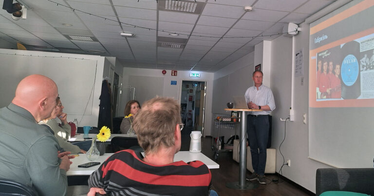 människor vid bord som tittar på projektorduk